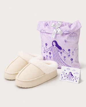 Pantusuecos Cuco marfil junto a su guardapolvos lila ilustrado y la tarjeta de Cuco